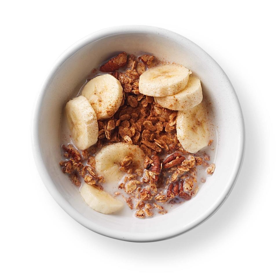 a bowl of oats with banana, nuts, and cinnamon powder